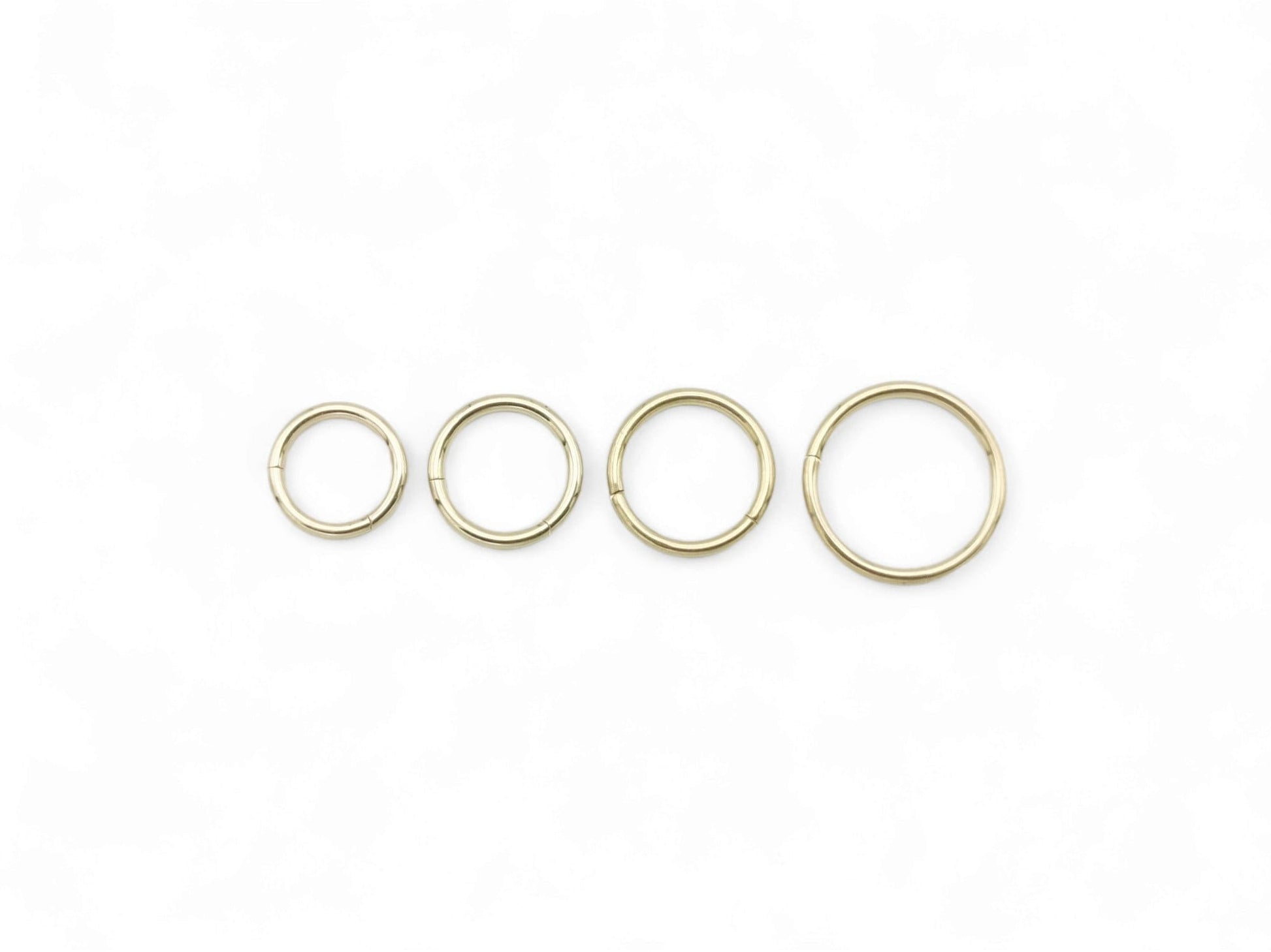 Four Gold steel clicker rings on a white background