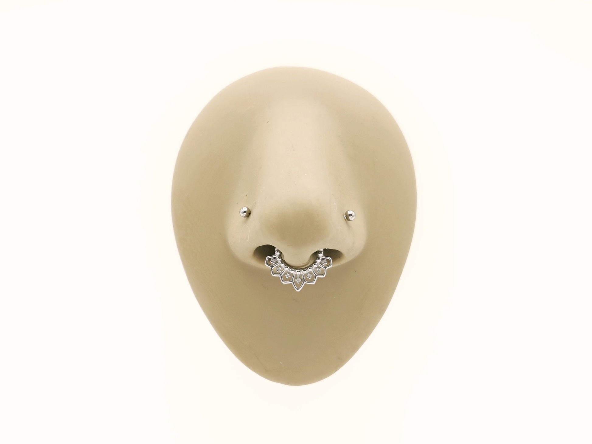 Surgical steel mandala clicker rings on a mannequins nose