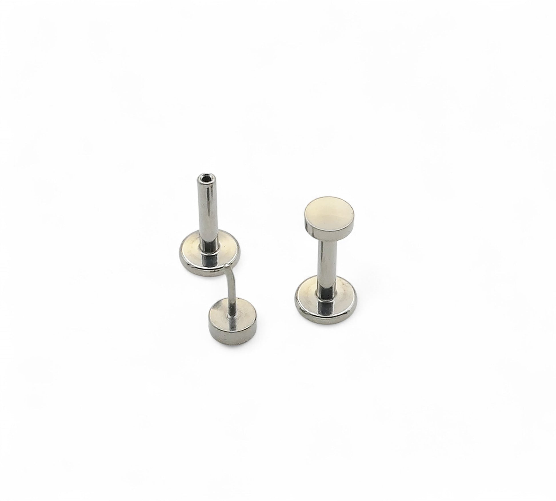 Two silver metal studs on a white background