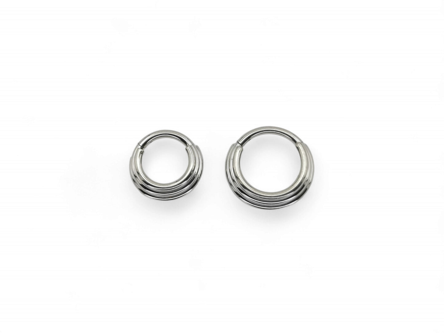 Two titanium illusion clicker rings with a bright polished finish, intended for septum piercings, presented on a white background.