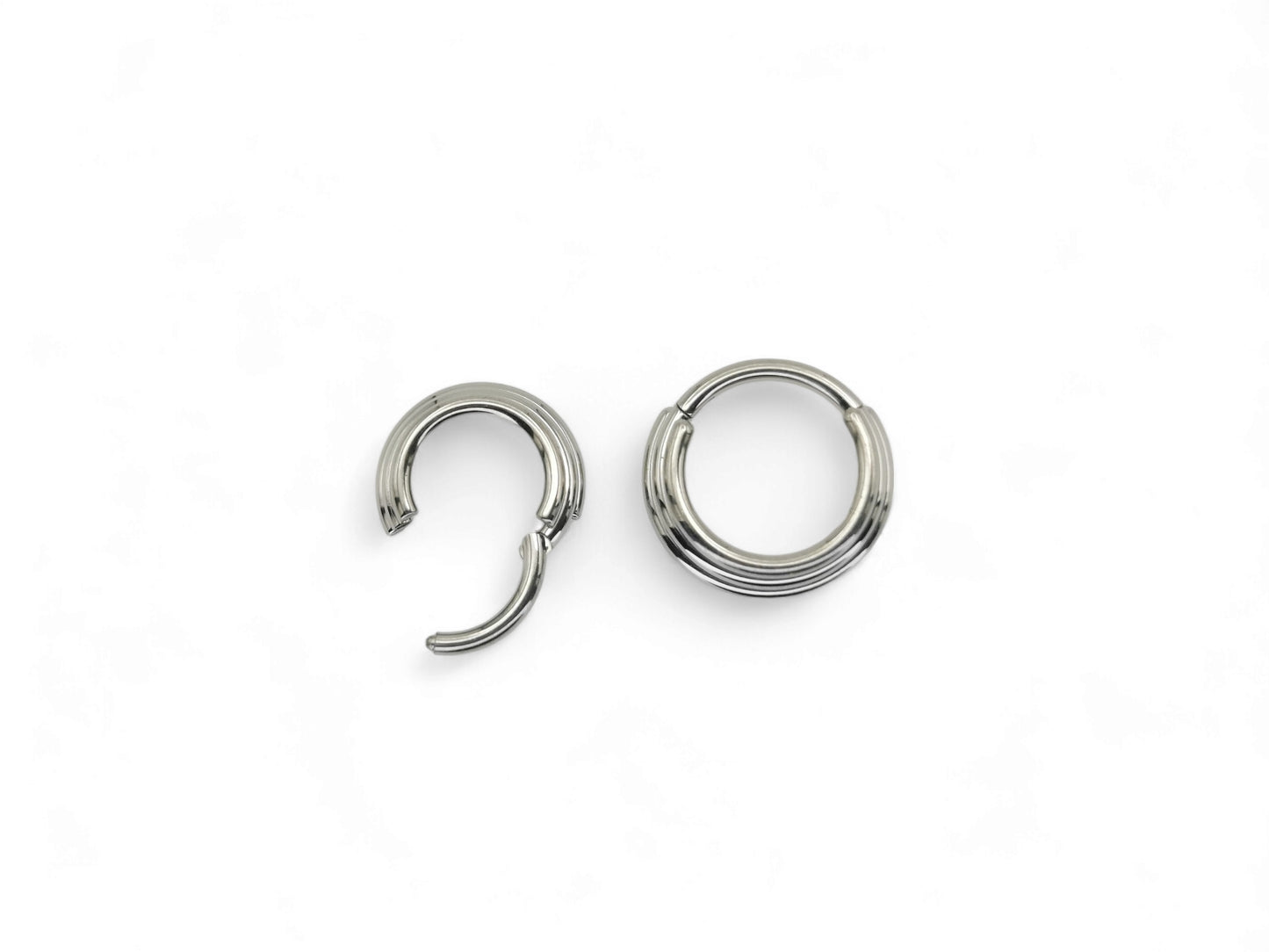 Two titanium illusion clicker rings with a bright polished finish, intended for septum piercings, presented on a white background.