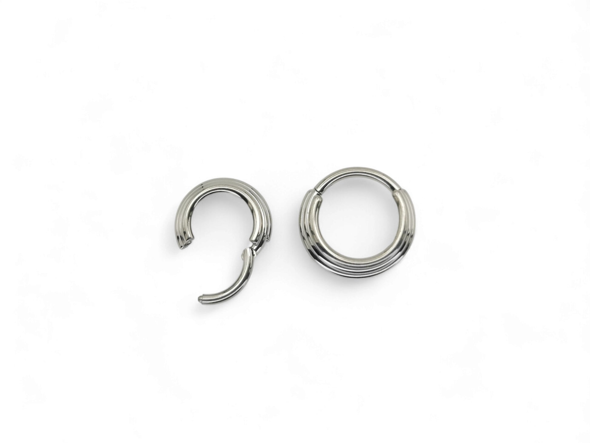 Two titanium illusion clicker rings with a bright polished finish, intended for septum piercings, presented on a white background.