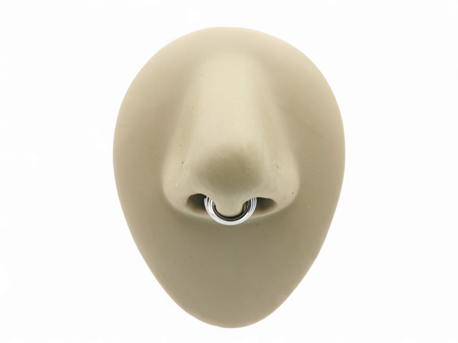Titanium illusion septum ring on a mannequin nose