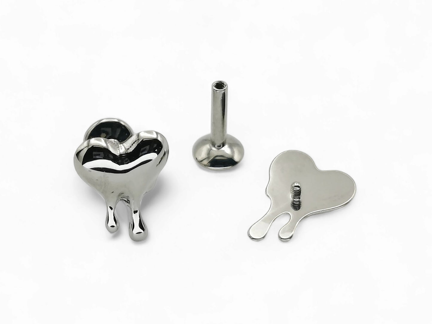 A silver-colored titanium melting heart stud jewelry piece displayed on a white background, consisting of a heart-shaped stud with a small ball on one end for piercing.