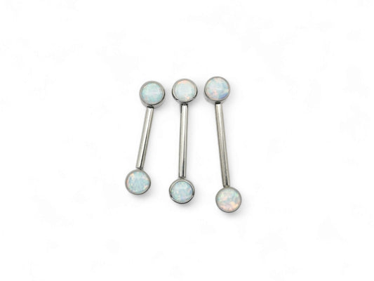 A set of three disc-shaped titanium nipple bars with bezel settings and white opal jewels.