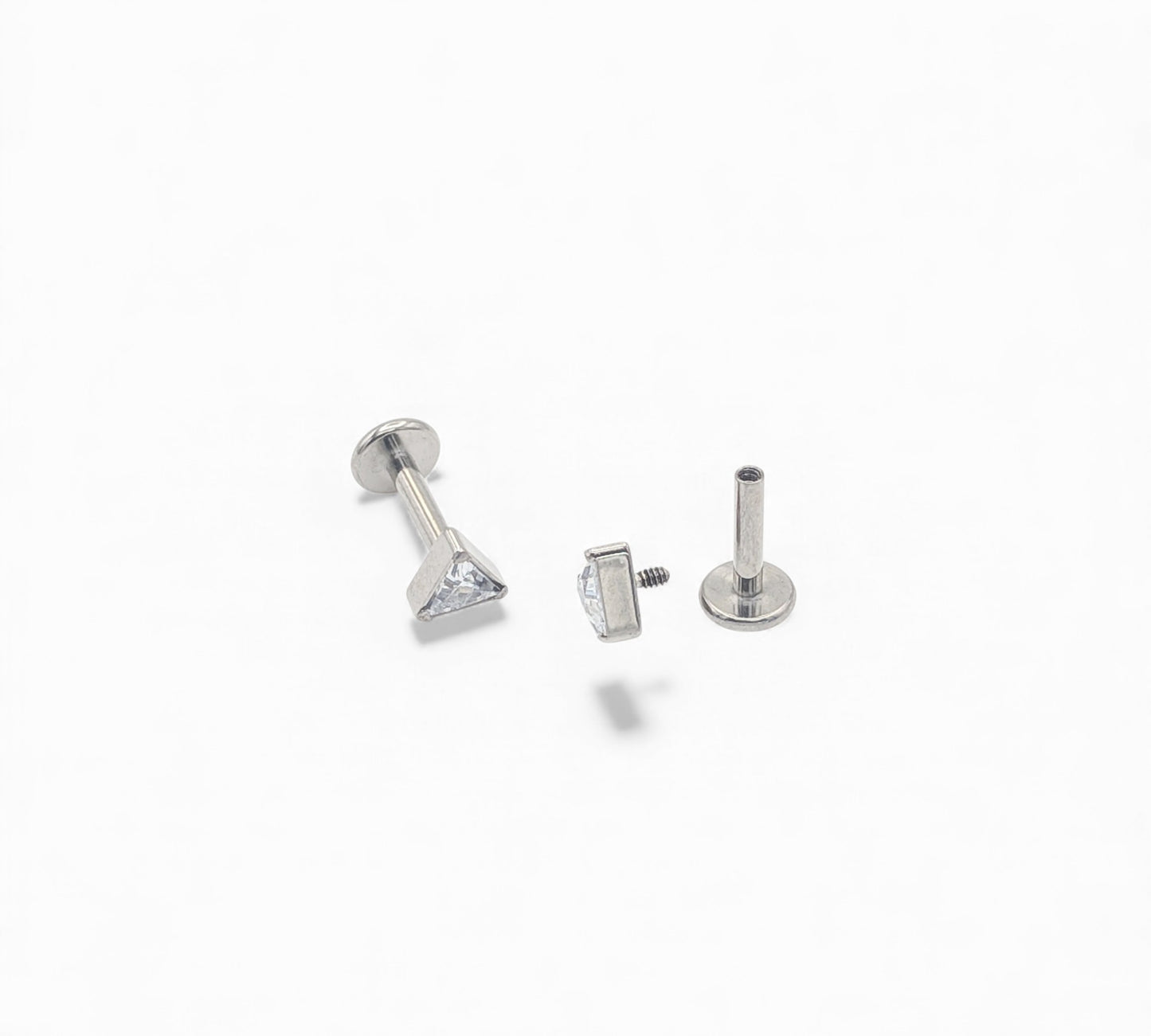 Three silver earring studs on a white background