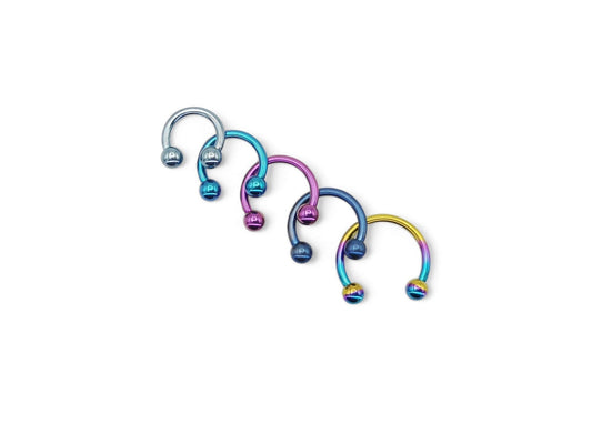 A selection of circular barbells in various colors, including blue, pink, and rainbow, designed for lip, ear, and septum piercings.