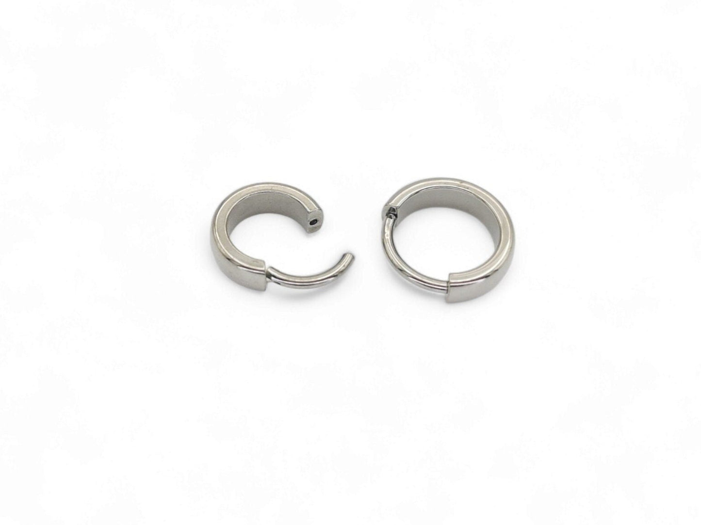Two titanium band clicker rings for ear and septum piercings, with a 1.2mm width, displayed on a white background.