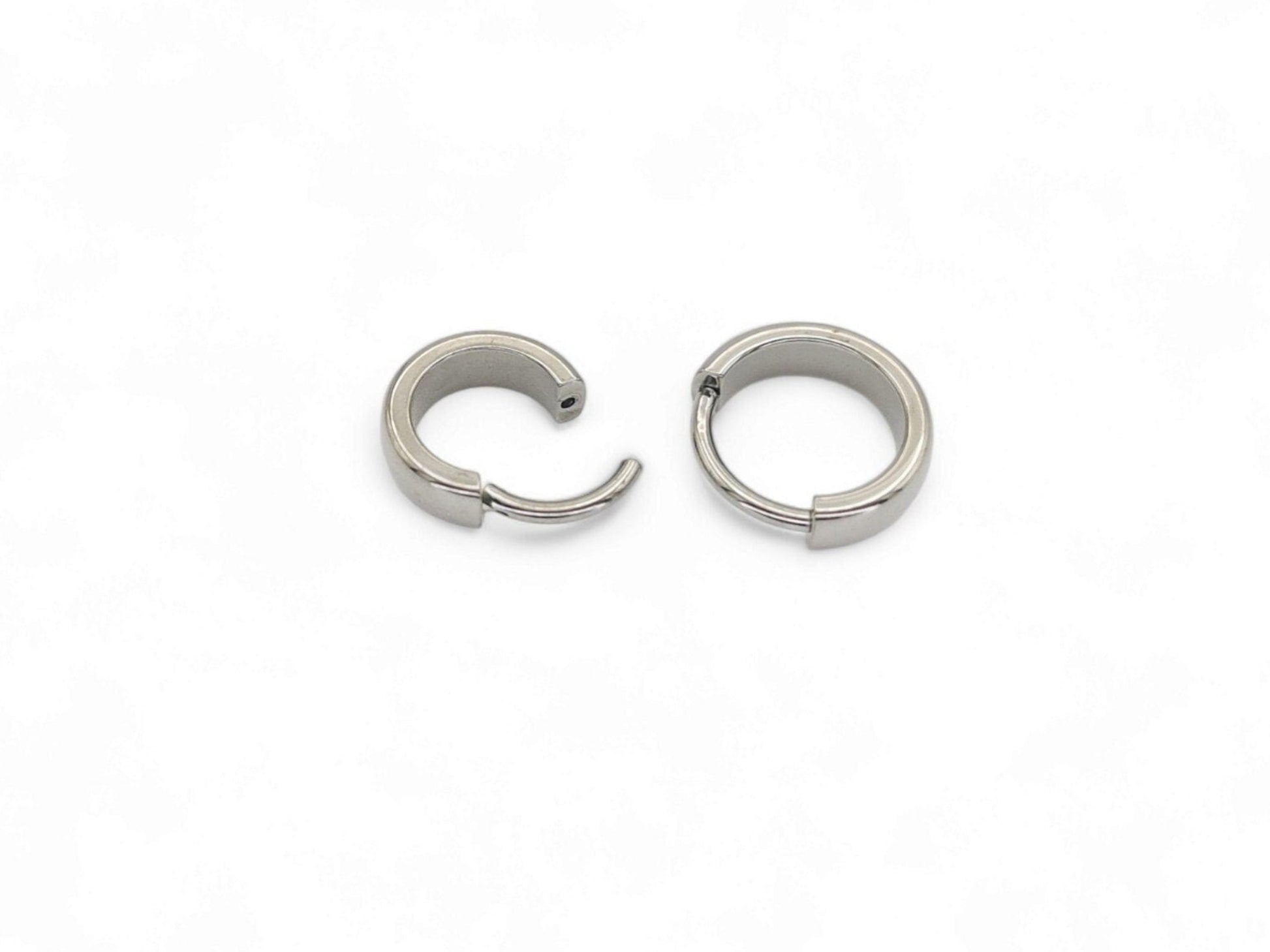 Two titanium band clicker rings for ear and septum piercings, with a 1.2mm width, displayed on a white background.