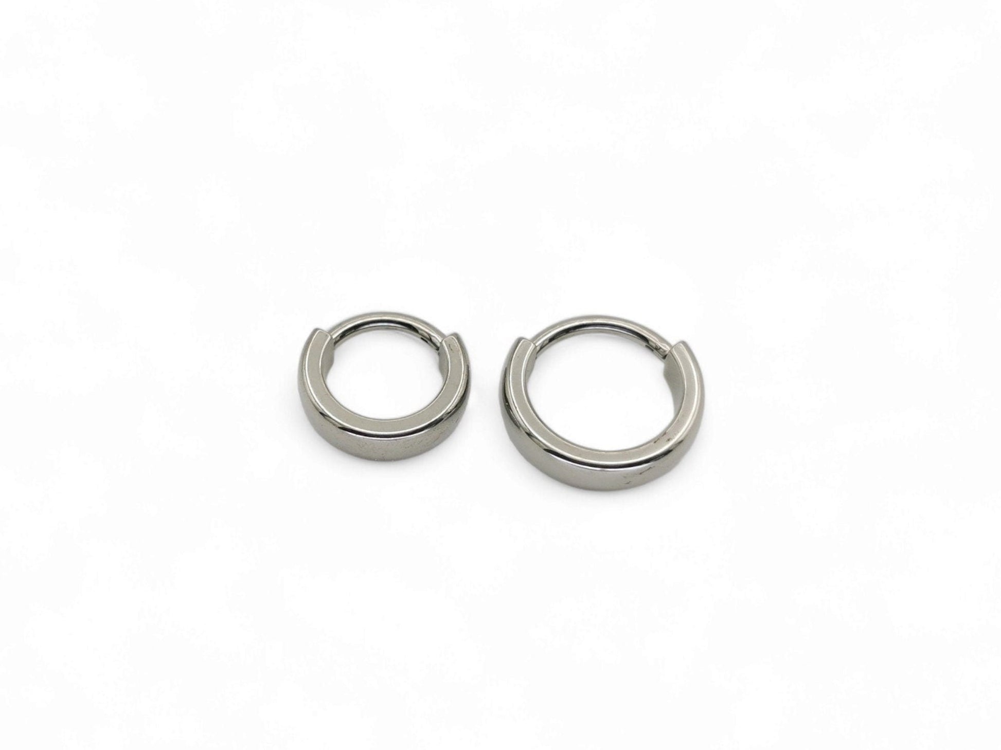 Two titanium band clicker rings for ear and septum piercings, with a 1.2mm width, displayed on a white background.