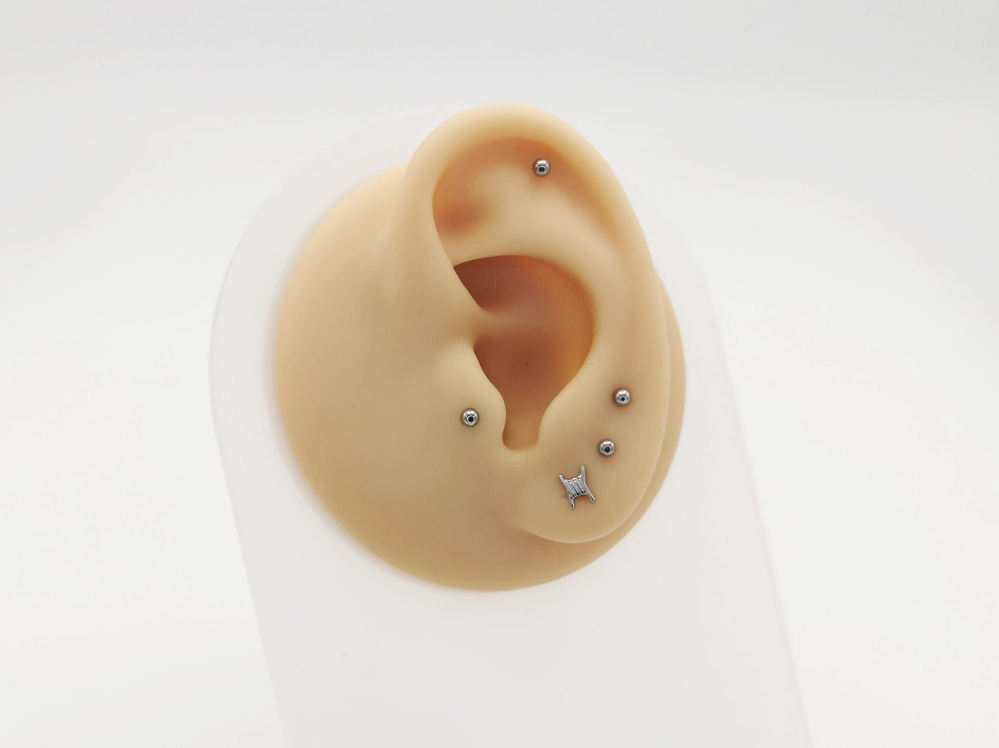 Two titanium barb wire threadless studs with a push-fit design