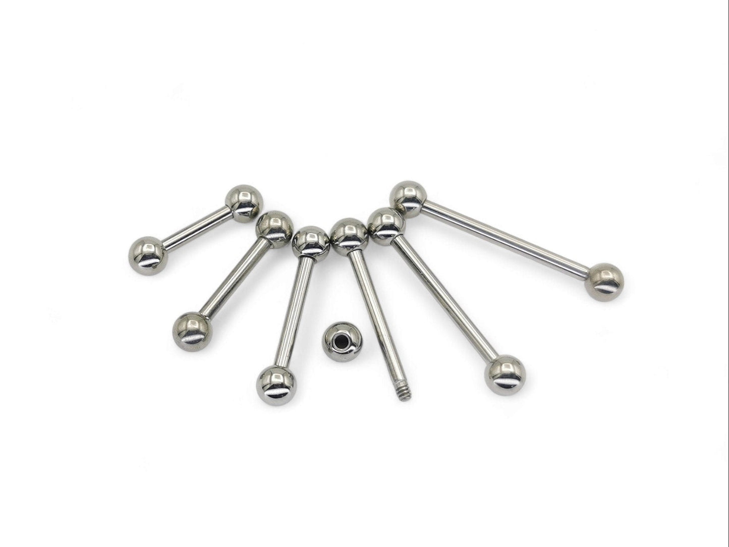 A set of polished titanium barbells with varying lengths, designed for piercings, presenting a metallic sheen.