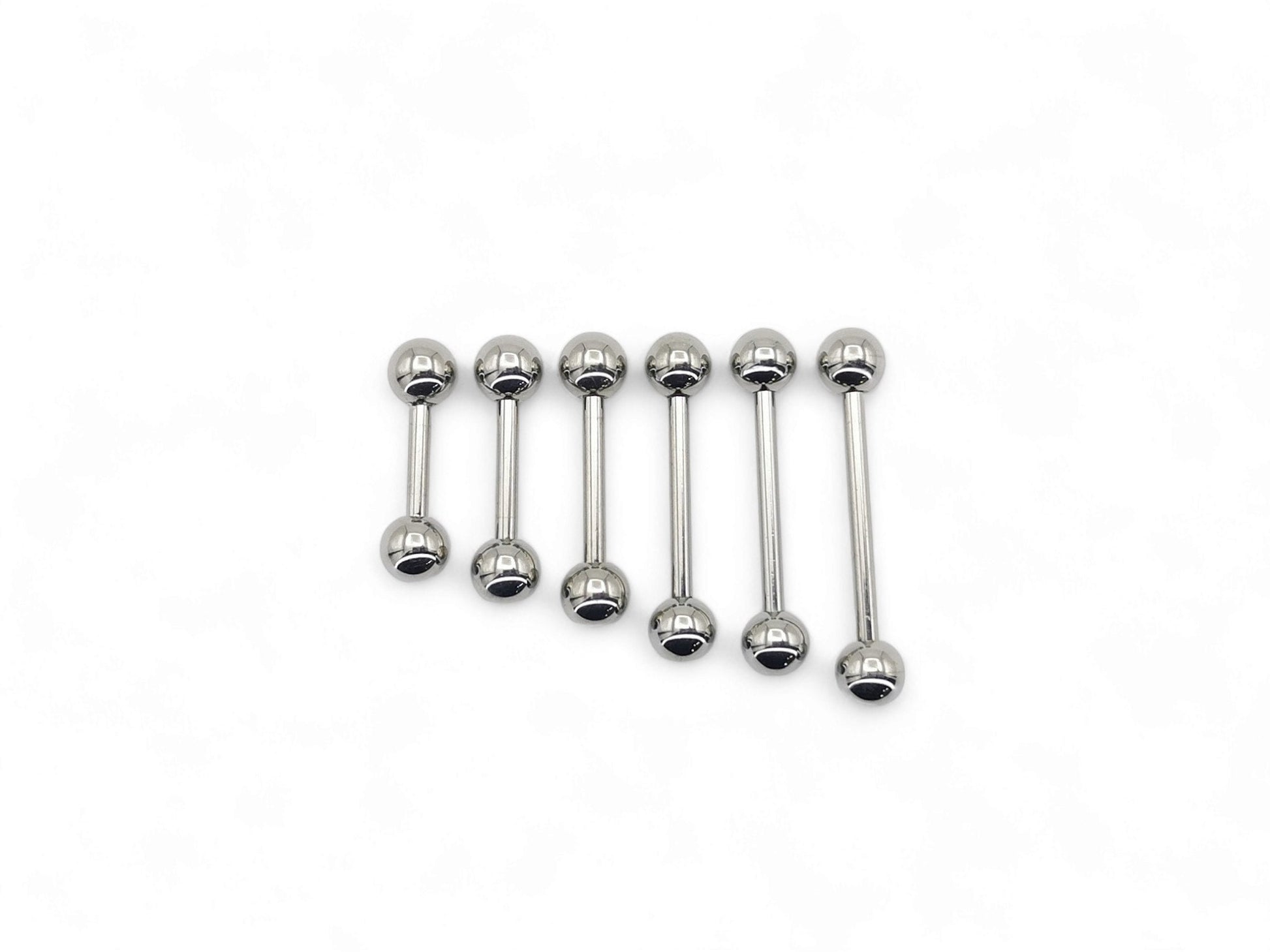 A set of polished titanium barbells with varying lengths, designed for piercings, presenting a metallic sheen.