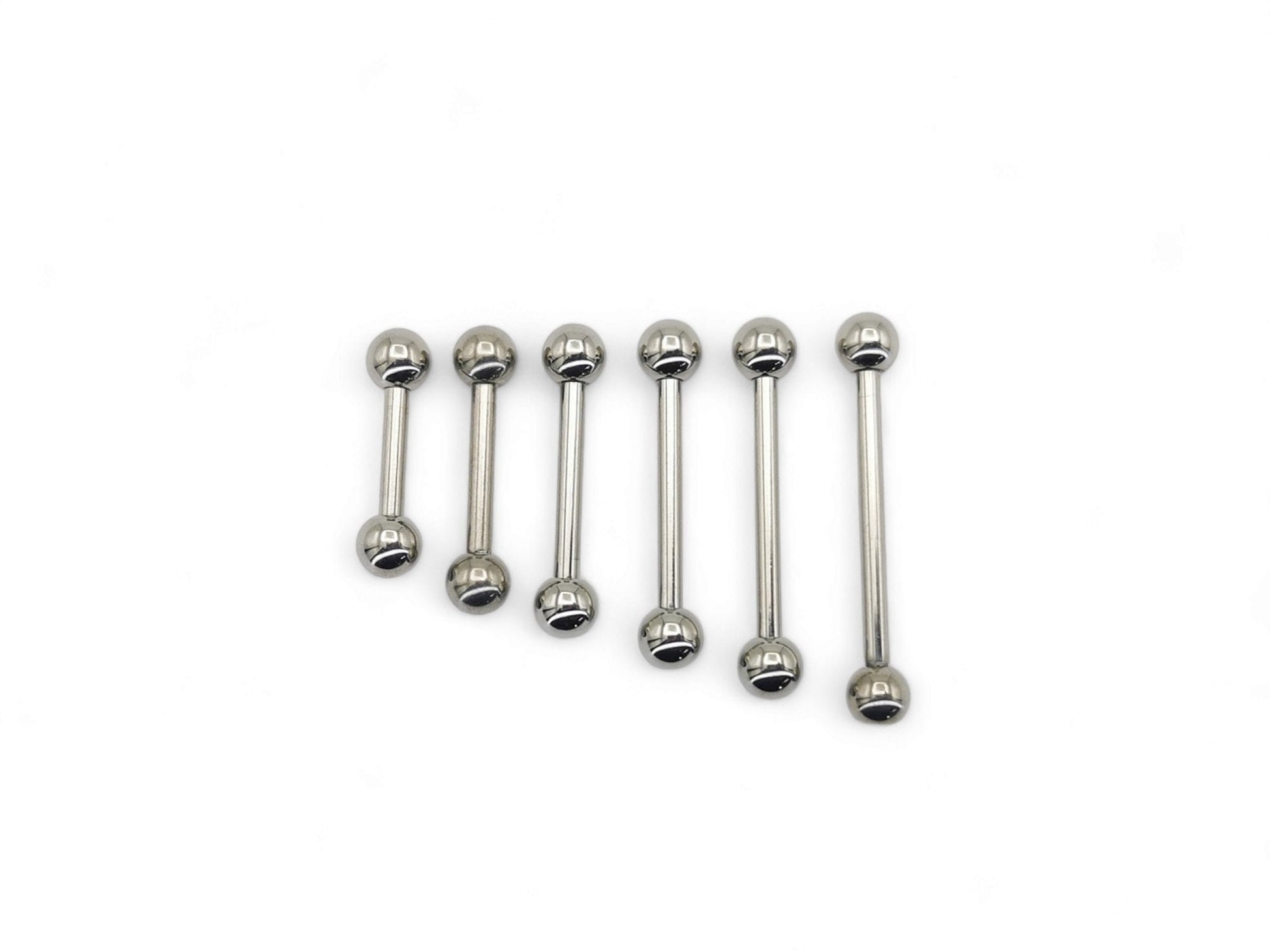 A set of polished titanium barbells with varying lengths, designed for piercings, presenting a metallic sheen.