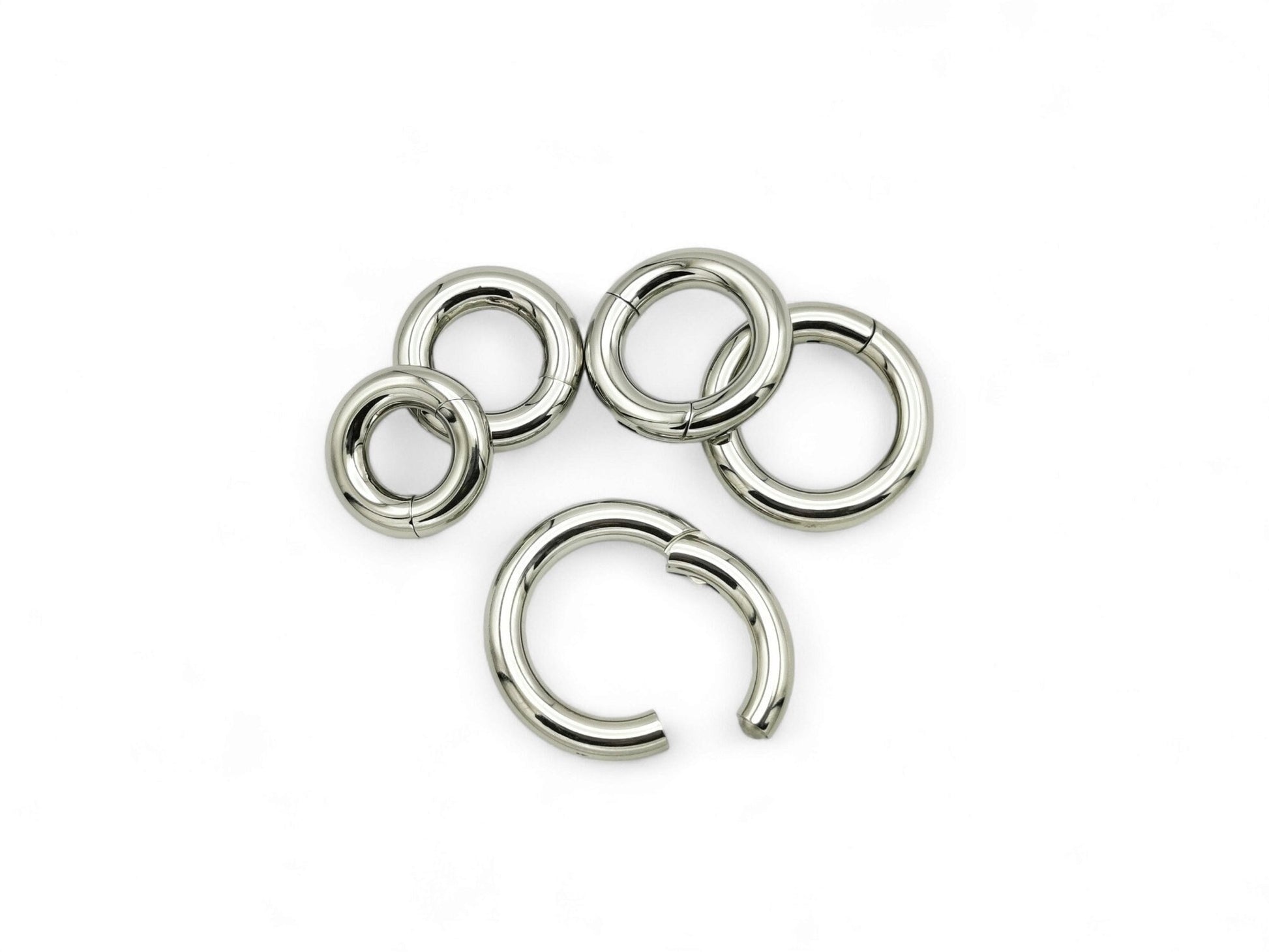 A set of five silver colour titanium clicker rings for piercings, displayed on a white background.