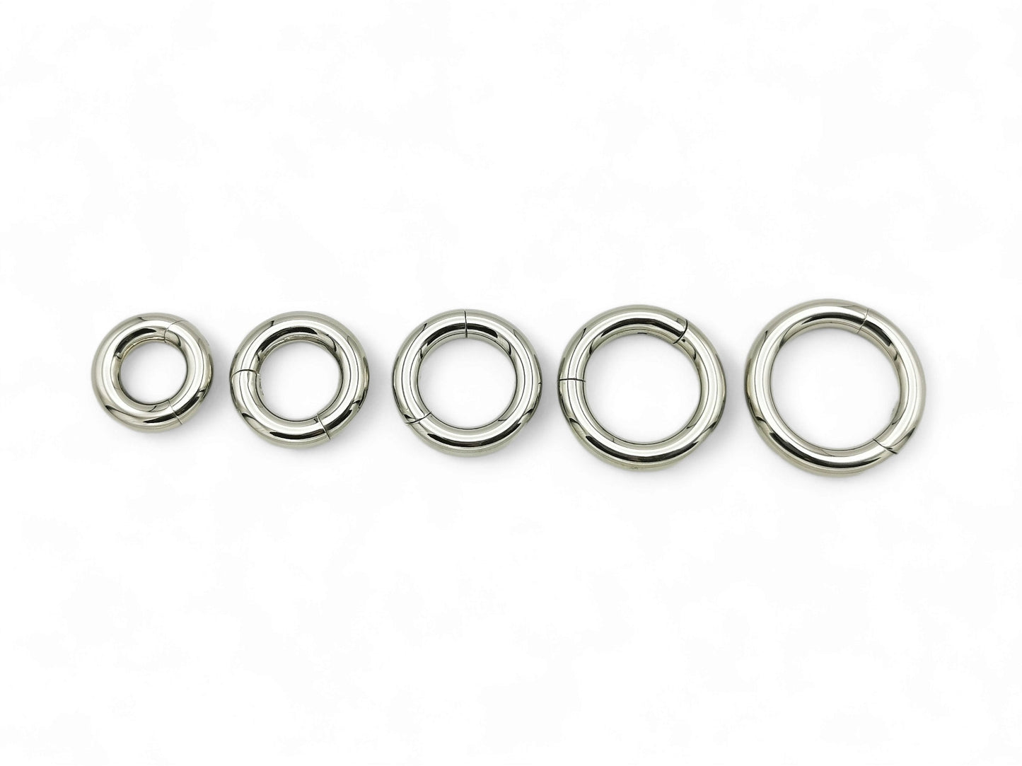 A set of five silver colour titanium clicker rings for piercings, displayed on a white background.