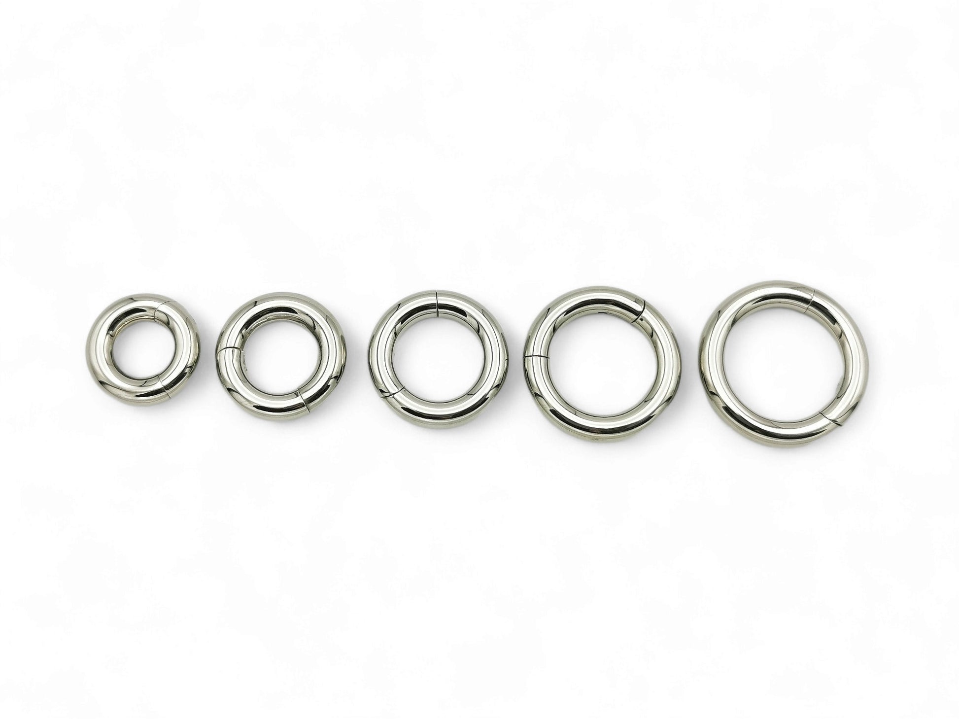 A set of five silver colour titanium clicker rings for piercings, displayed on a white background.