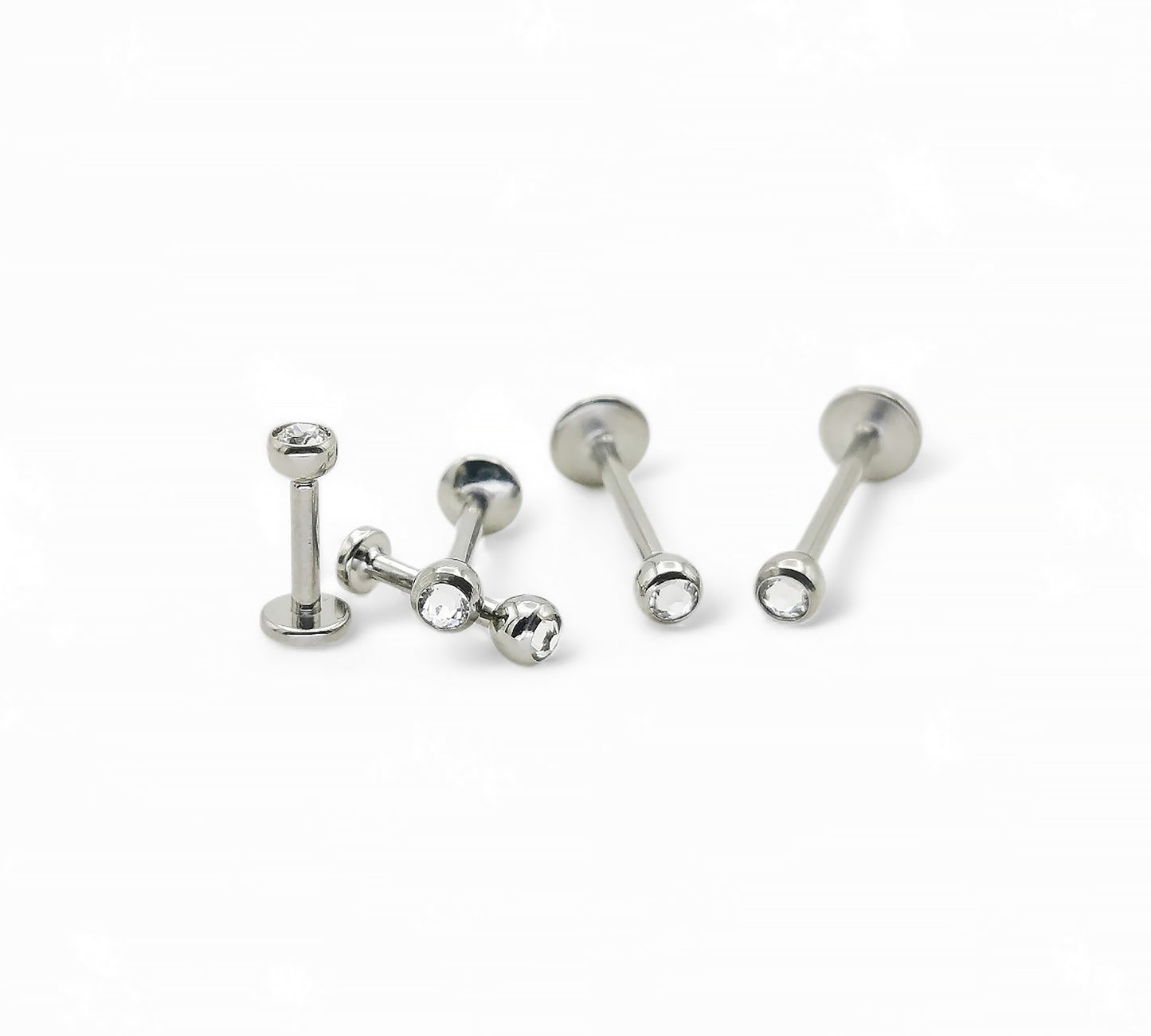 A collection of titanium threaded jewelled studs in various lengths, each featuring a clear crystal ball.