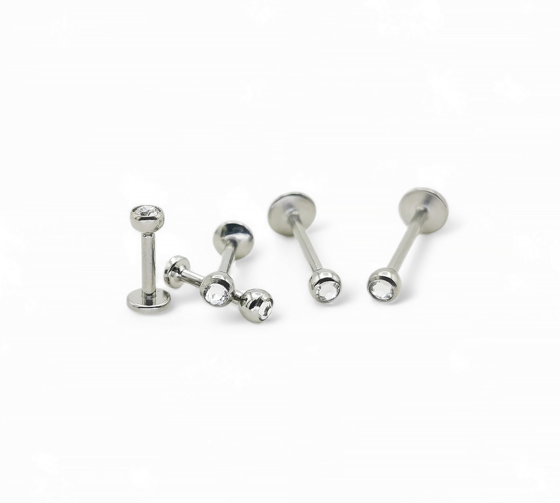 A collection of titanium threaded jewelled studs in various lengths, each featuring a clear crystal ball.