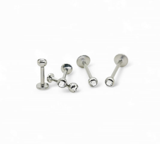 A collection of titanium threaded jewelled studs in various lengths, each featuring a clear crystal ball.