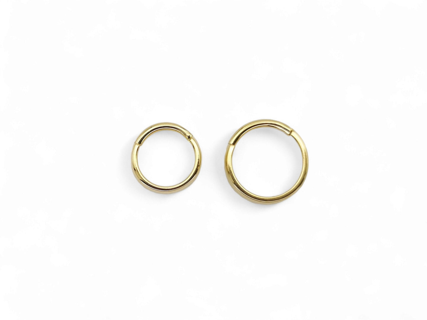 Titanium gold band clicker ring on a white background