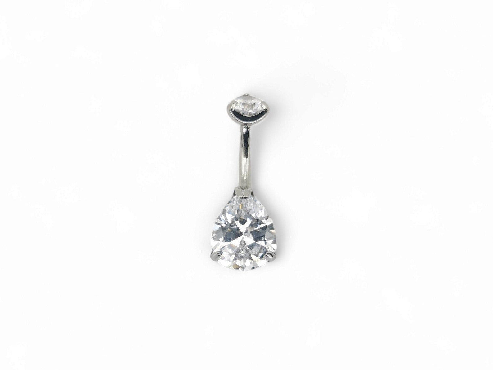 Titanium jewelled claw set belly bar with a brilliant cut pear gem and a round brilliant cut gem, set in a silver-tone mounting.