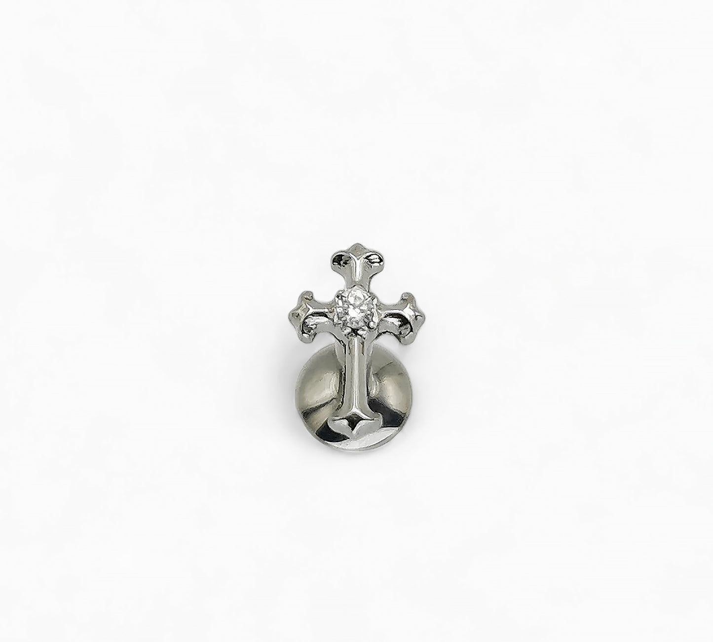 Silver cross-shaped earring with a clear gemstone on a white background