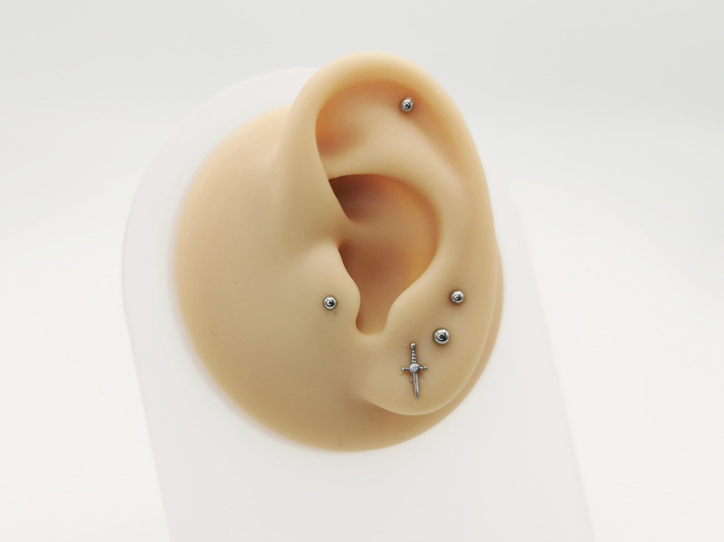 Sword-shaped earrings with gemstones on a white background