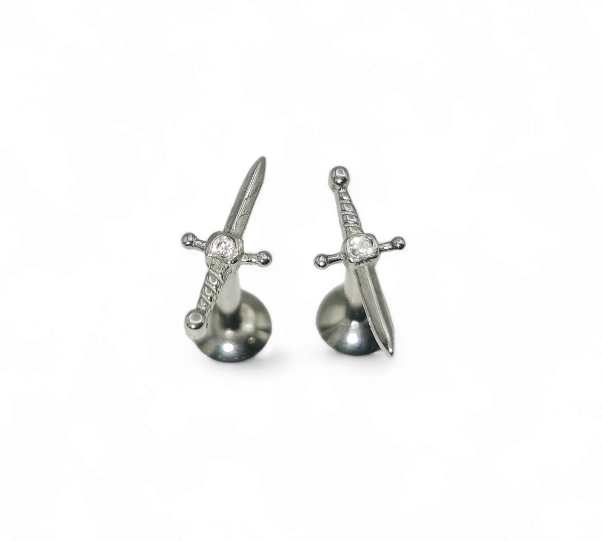 Sword-shaped earrings with gemstones on a white background
