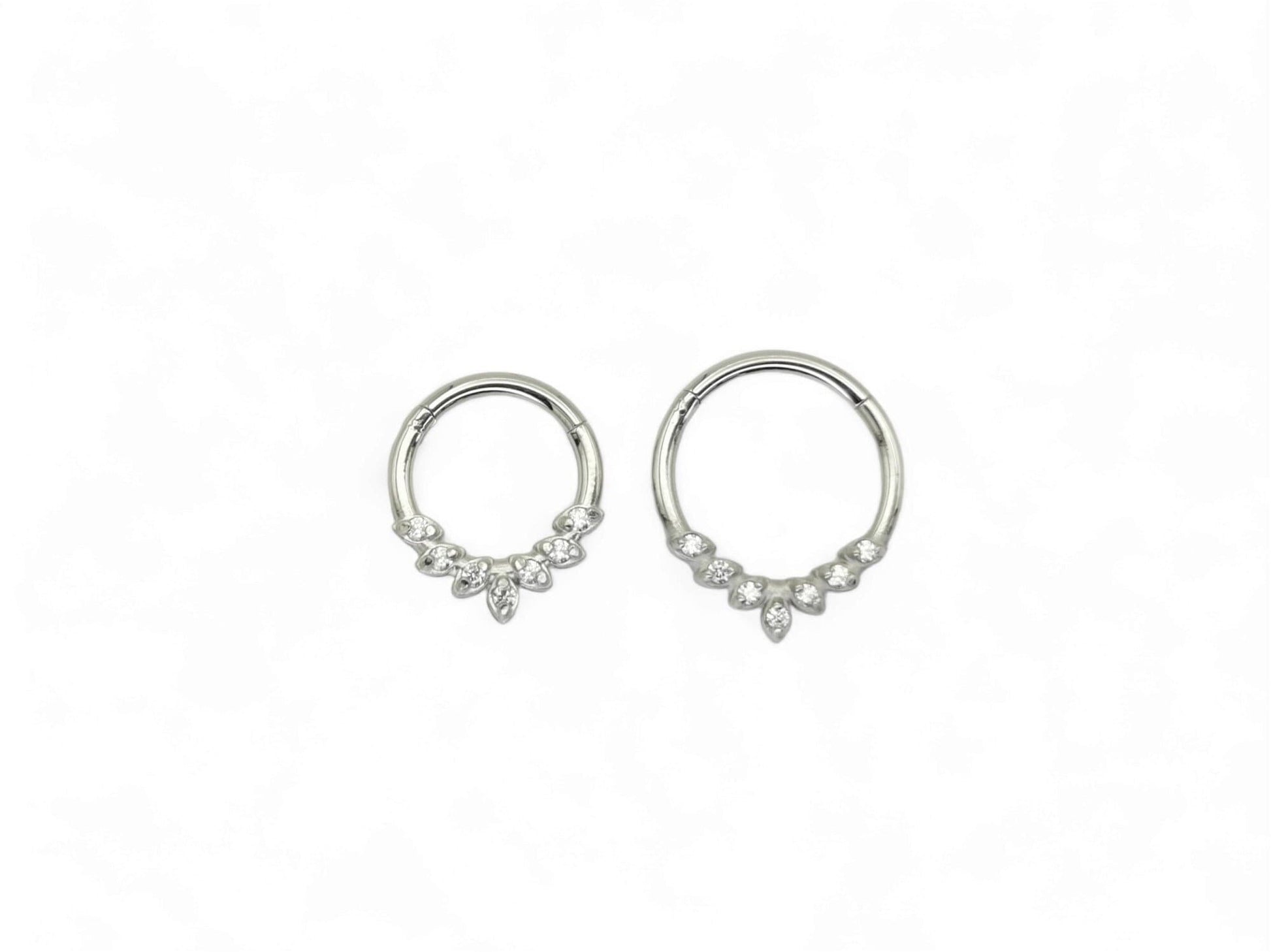 A pair of Titanium jewelled clicker rings with a laurel wreath detail, featuring cubic zirconia jewels.