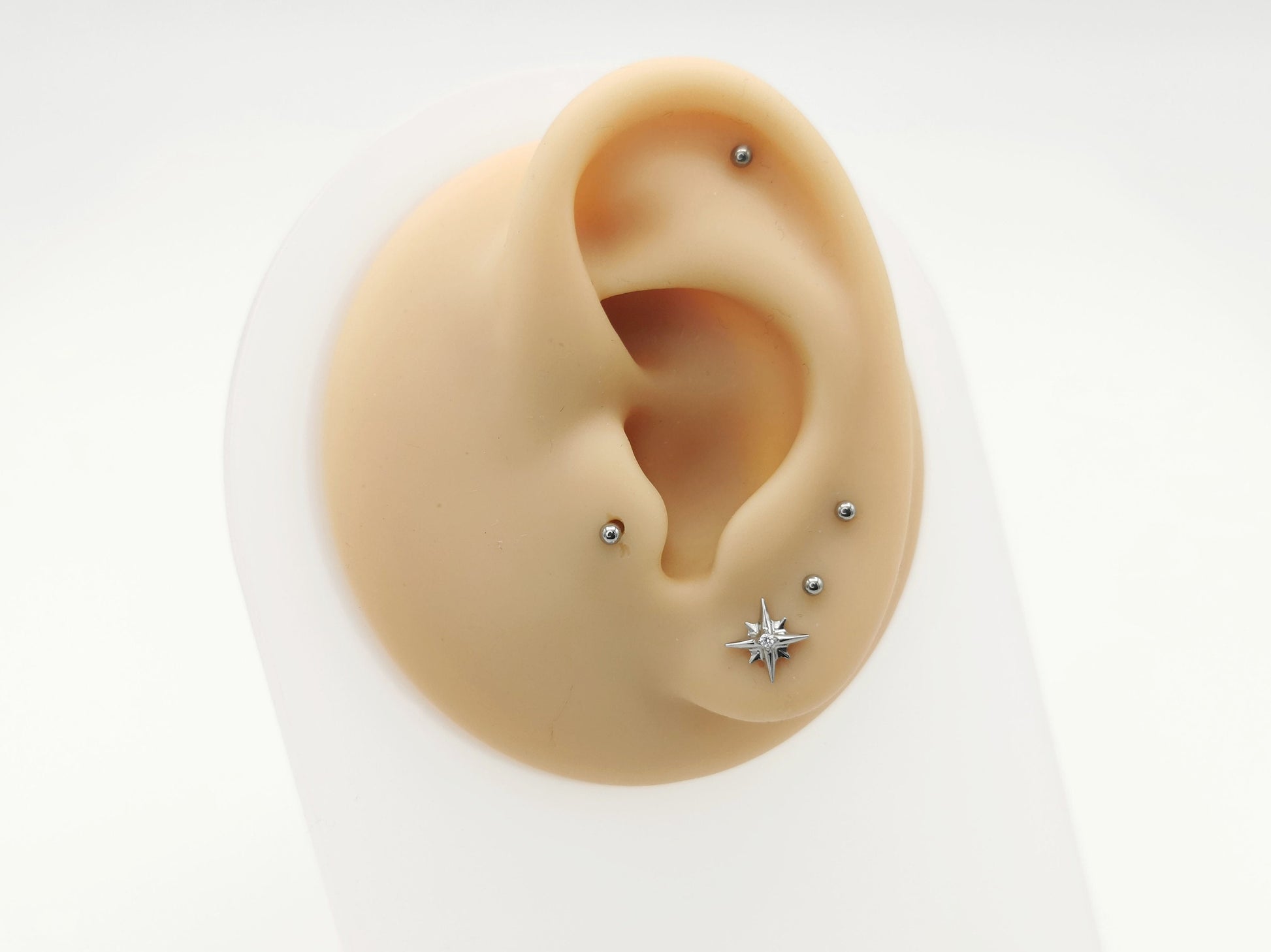 Titanium jewelled star stud on a mannequin ear