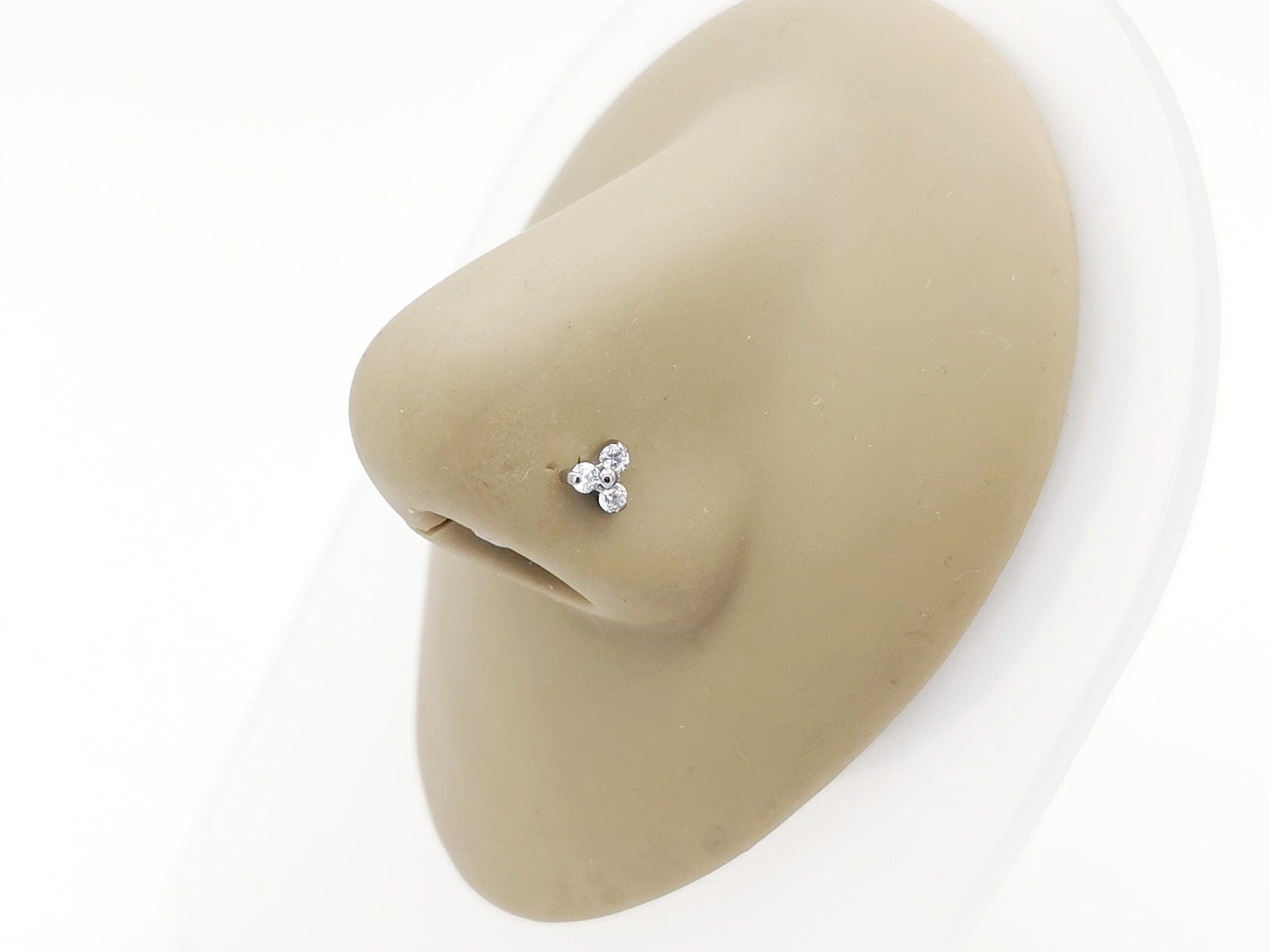 Titanium jewelled trinity nostril stud on a nose
