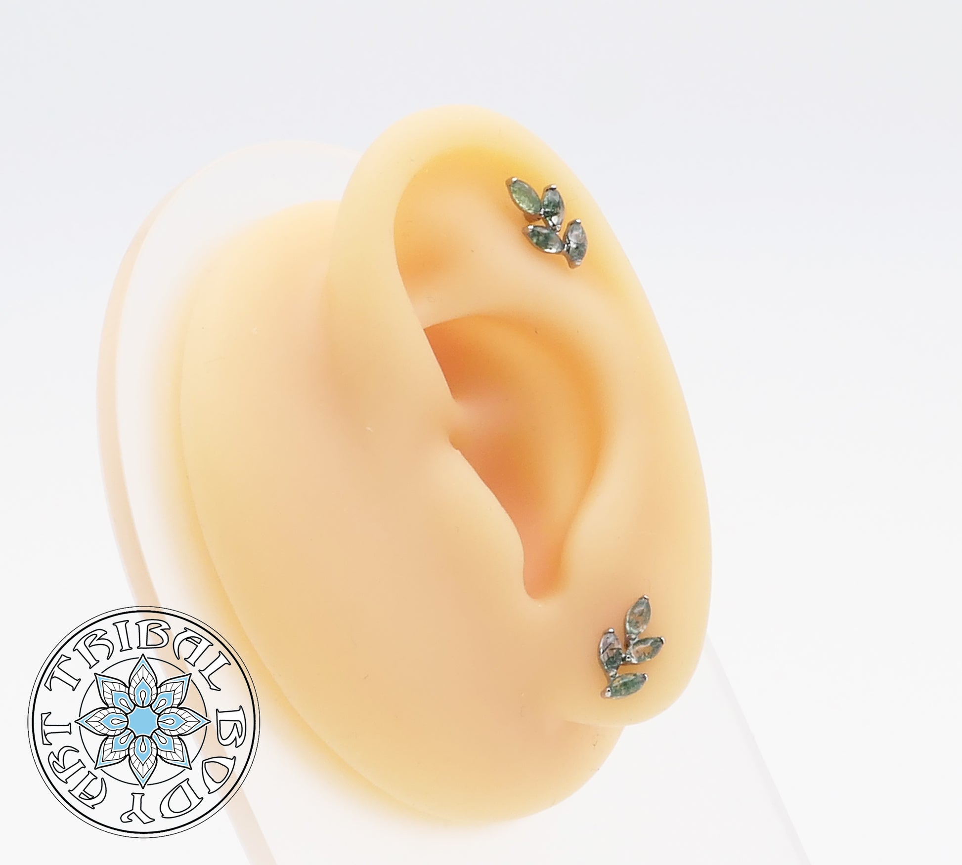 A pair of titanium moss agate leaf stud earrings with marquise-cut green stones set in a polished finish.