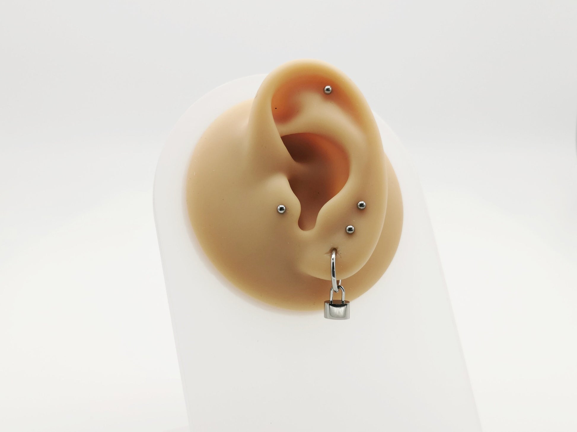 Titanium padlock charm on a mannequin ear