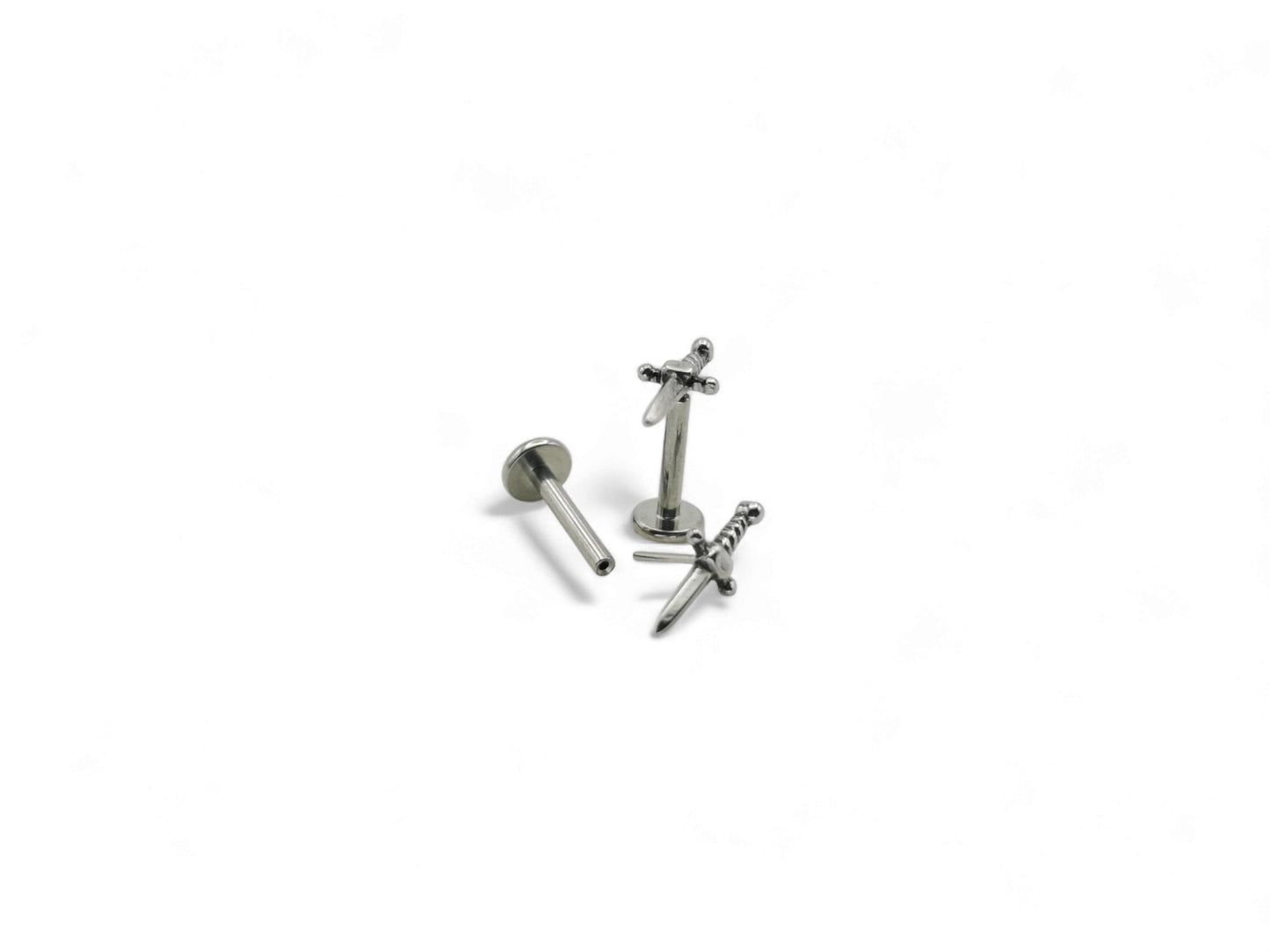Two polished stainless steel dagger studs with a push fit mechanism for body jewelry, isolated on a white background.