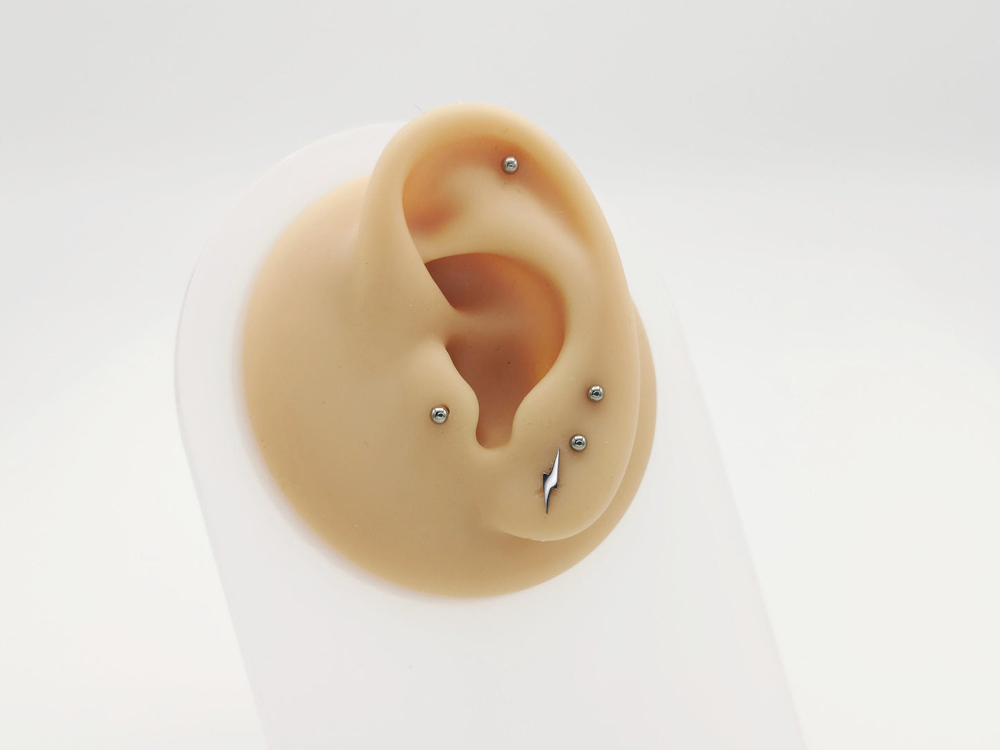 Titanium push fit lightening bolt stud on a mannequin ear