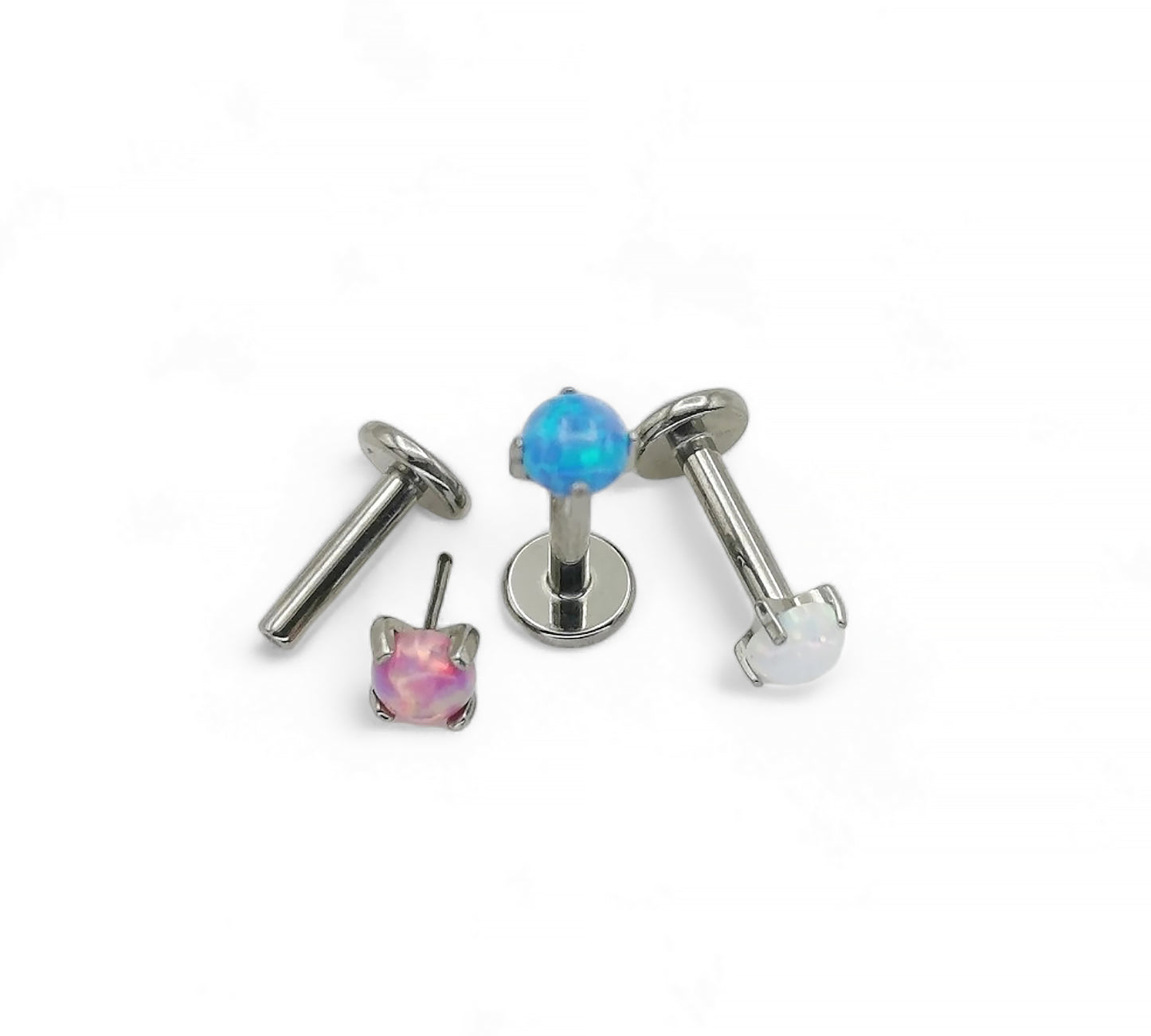 A collection of titanium push fit jewelled threadless studs in various colors including blue, pink, and clear, designed for use in multiple piercing types.