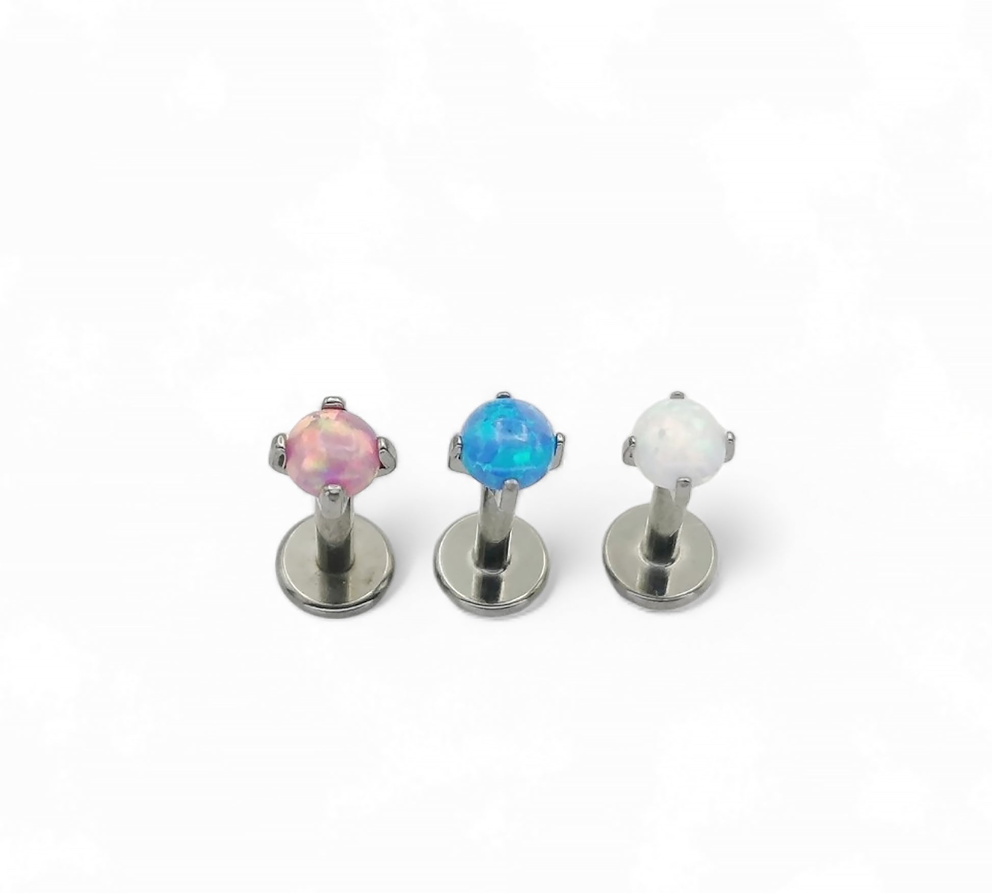 Three metallic earrings with colorful gemstones on a white background