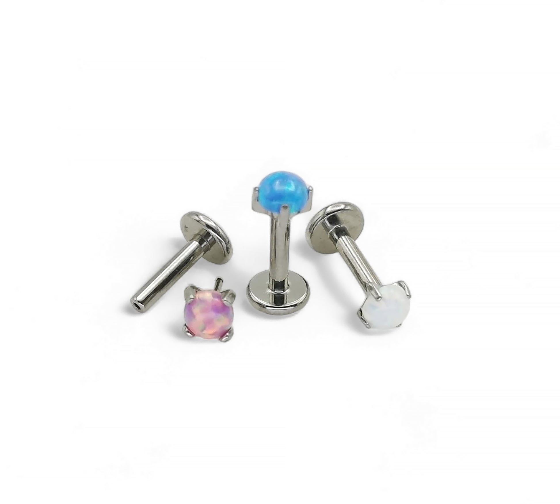 Three labret earrings with colorful gemstones on a white background