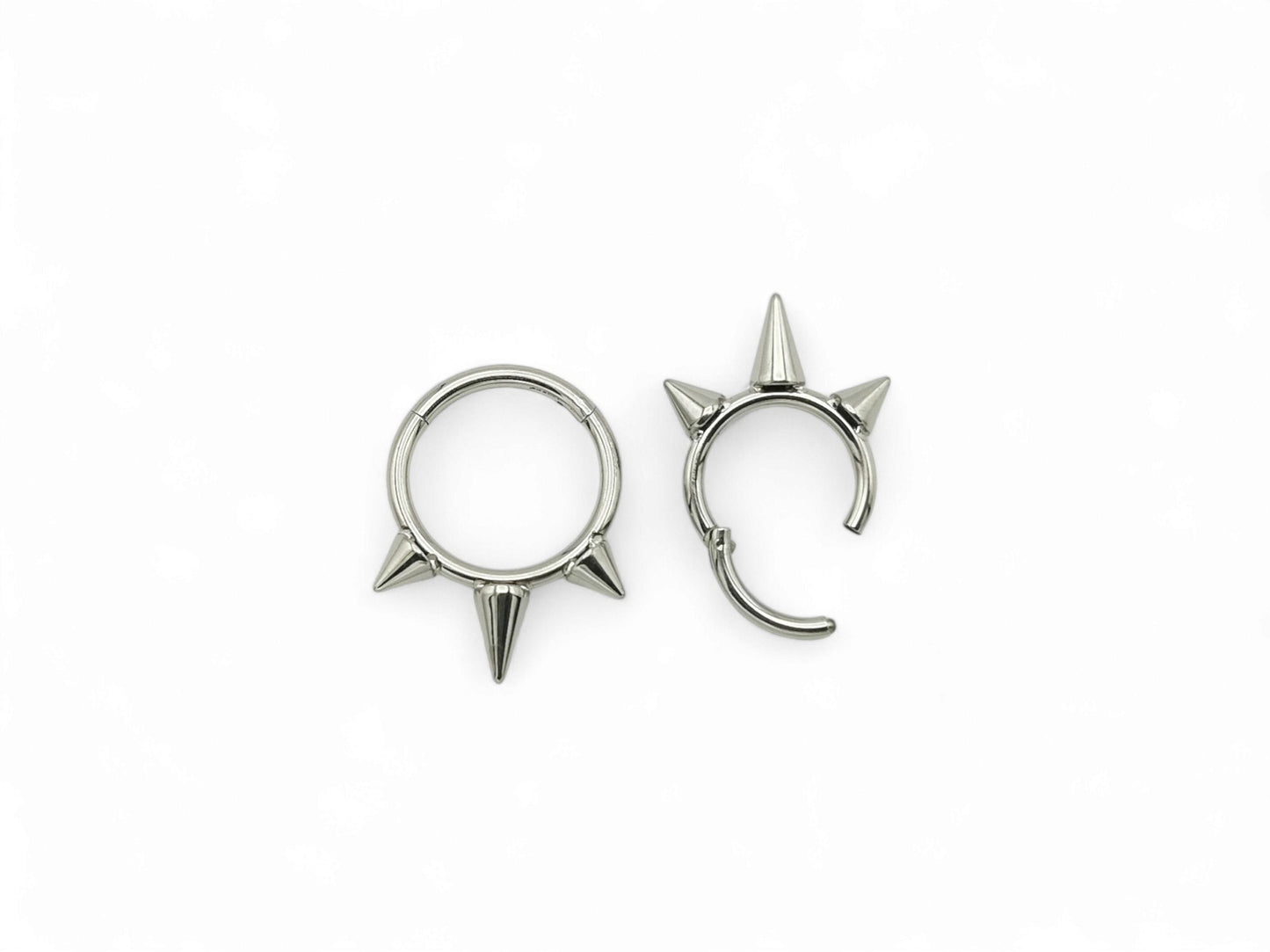 Titanium spike clicker rings on a white background