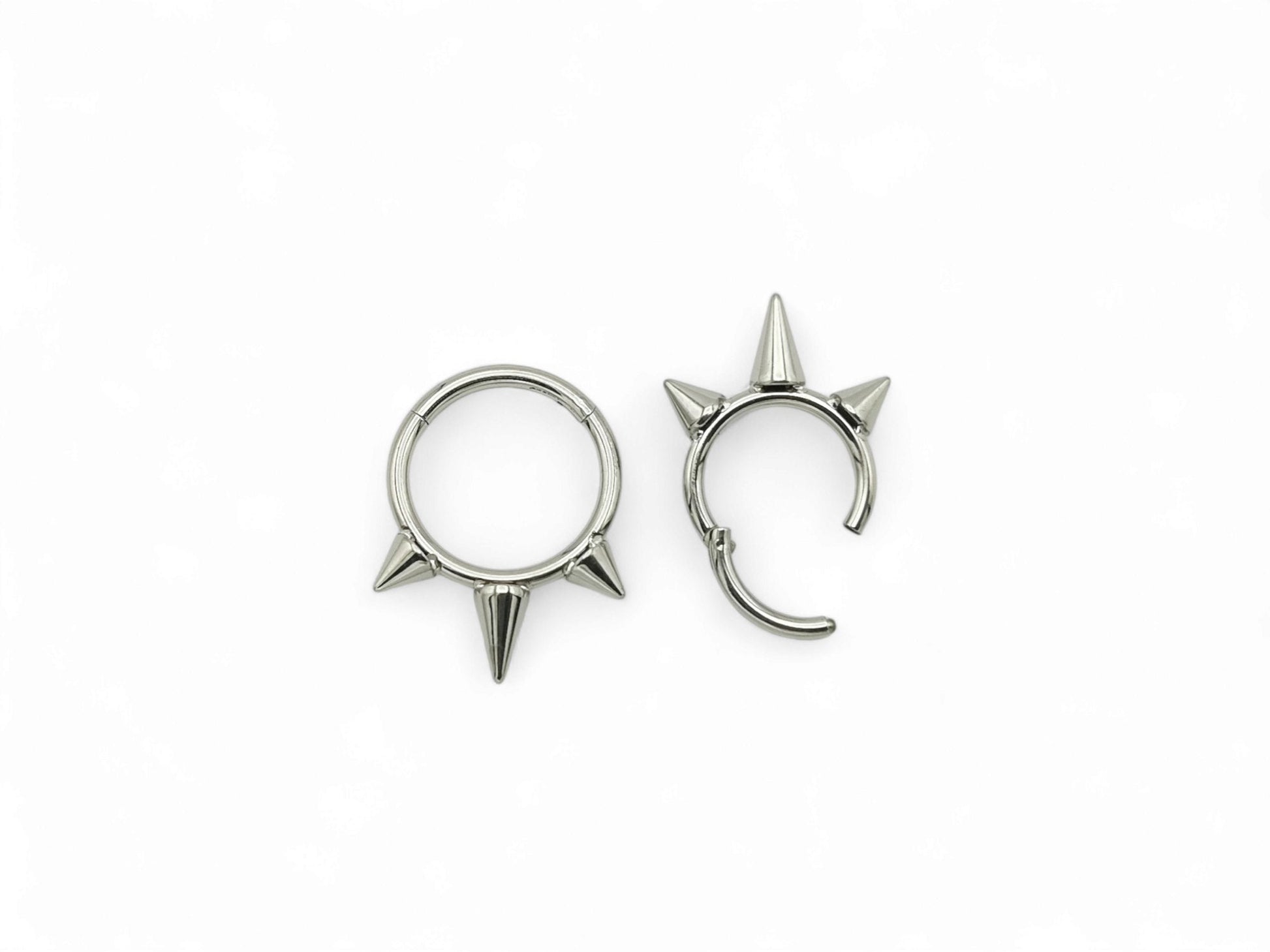 Titanium spike clicker rings on a white background