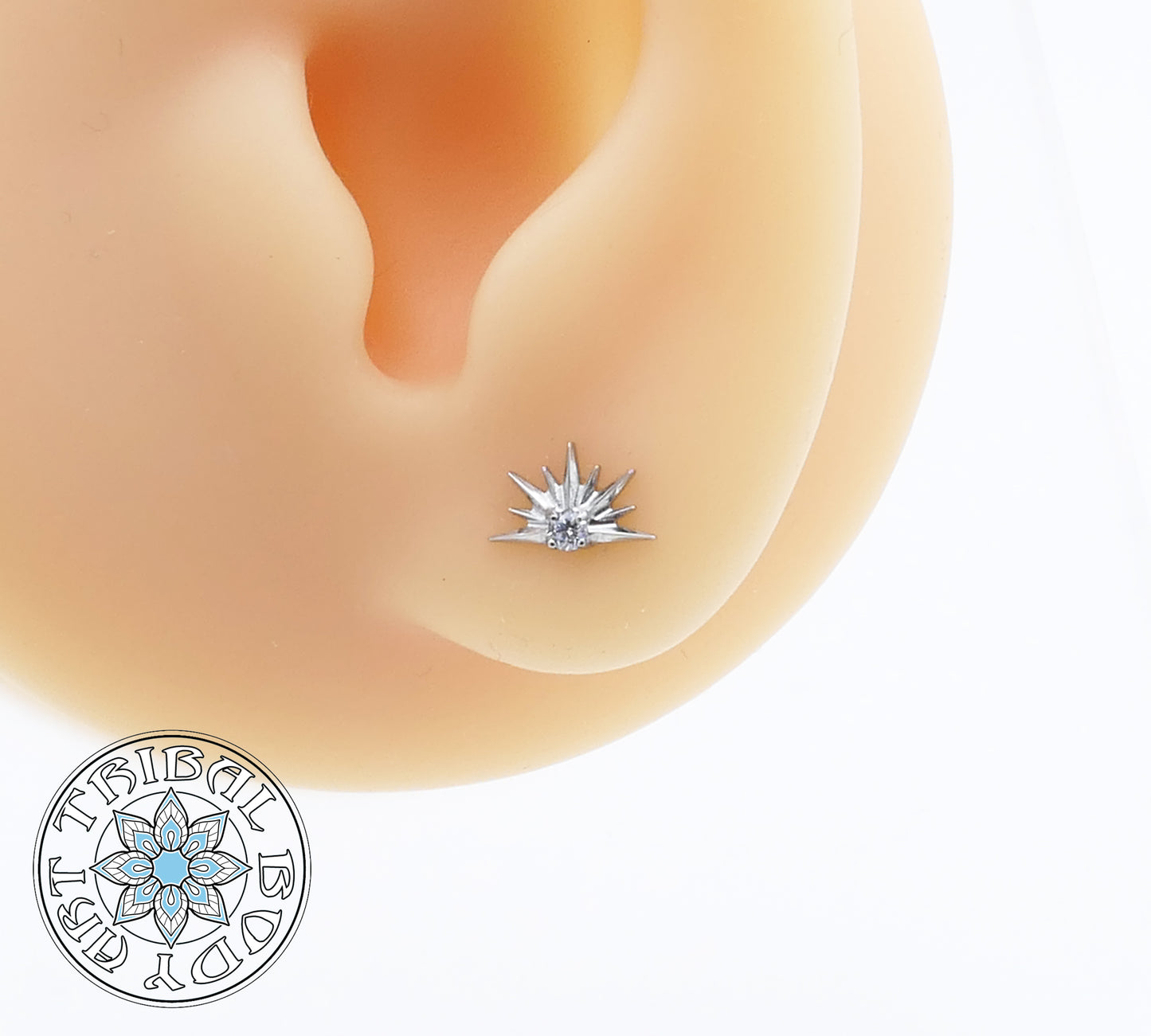Star-shaped earring on a person's ear with a visible brand logo.