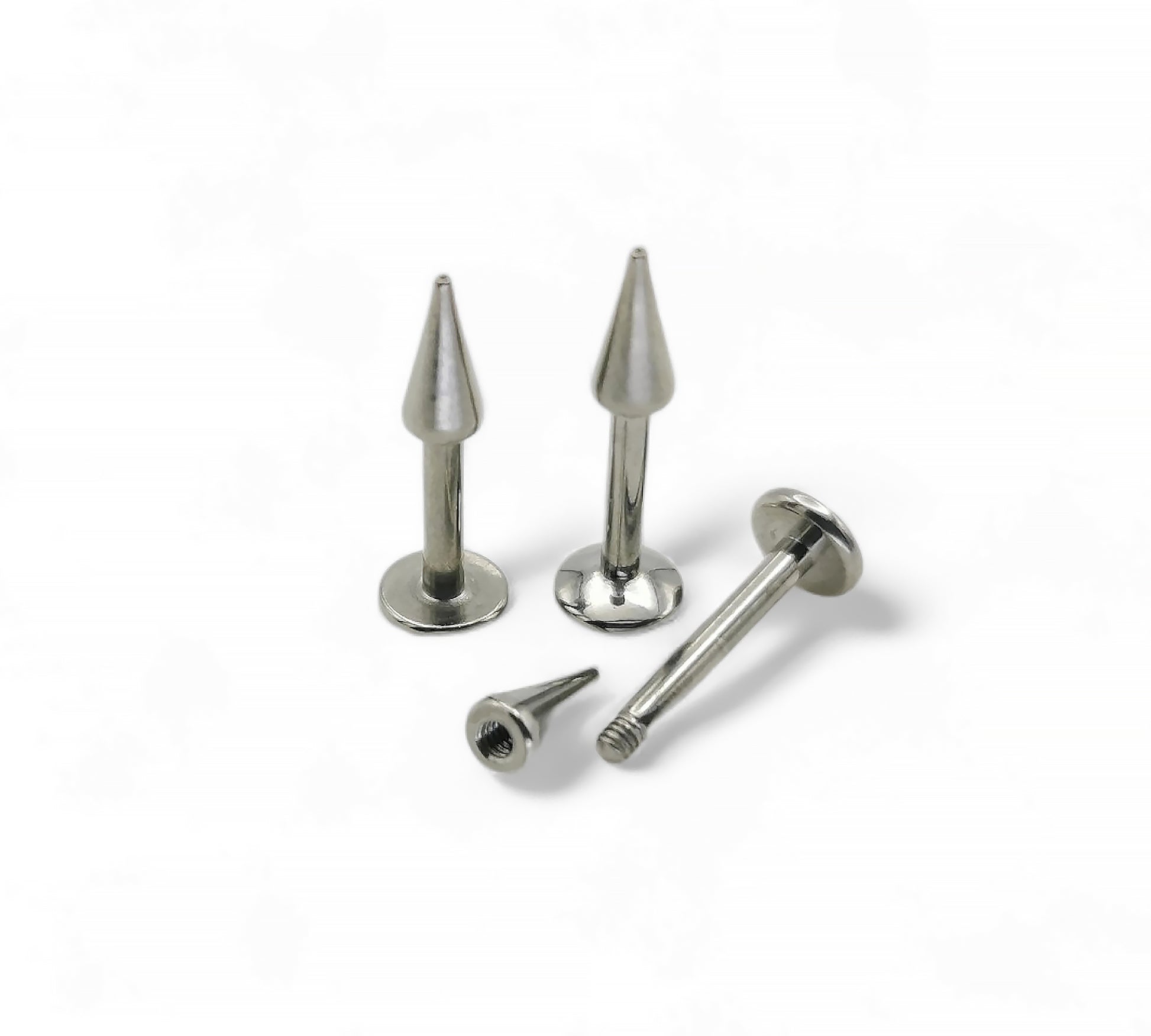 A collection of titanium spike labret studs in various lengths, with a flat disc back, displayed on a white background.