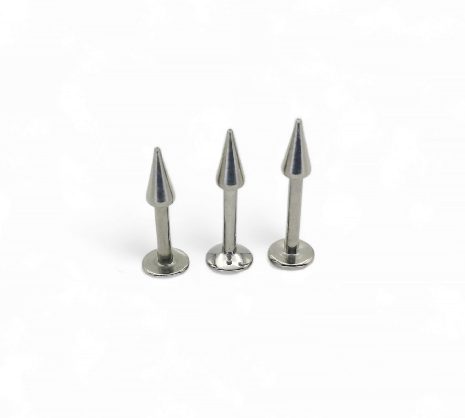 Three metallic spike pins on a white background