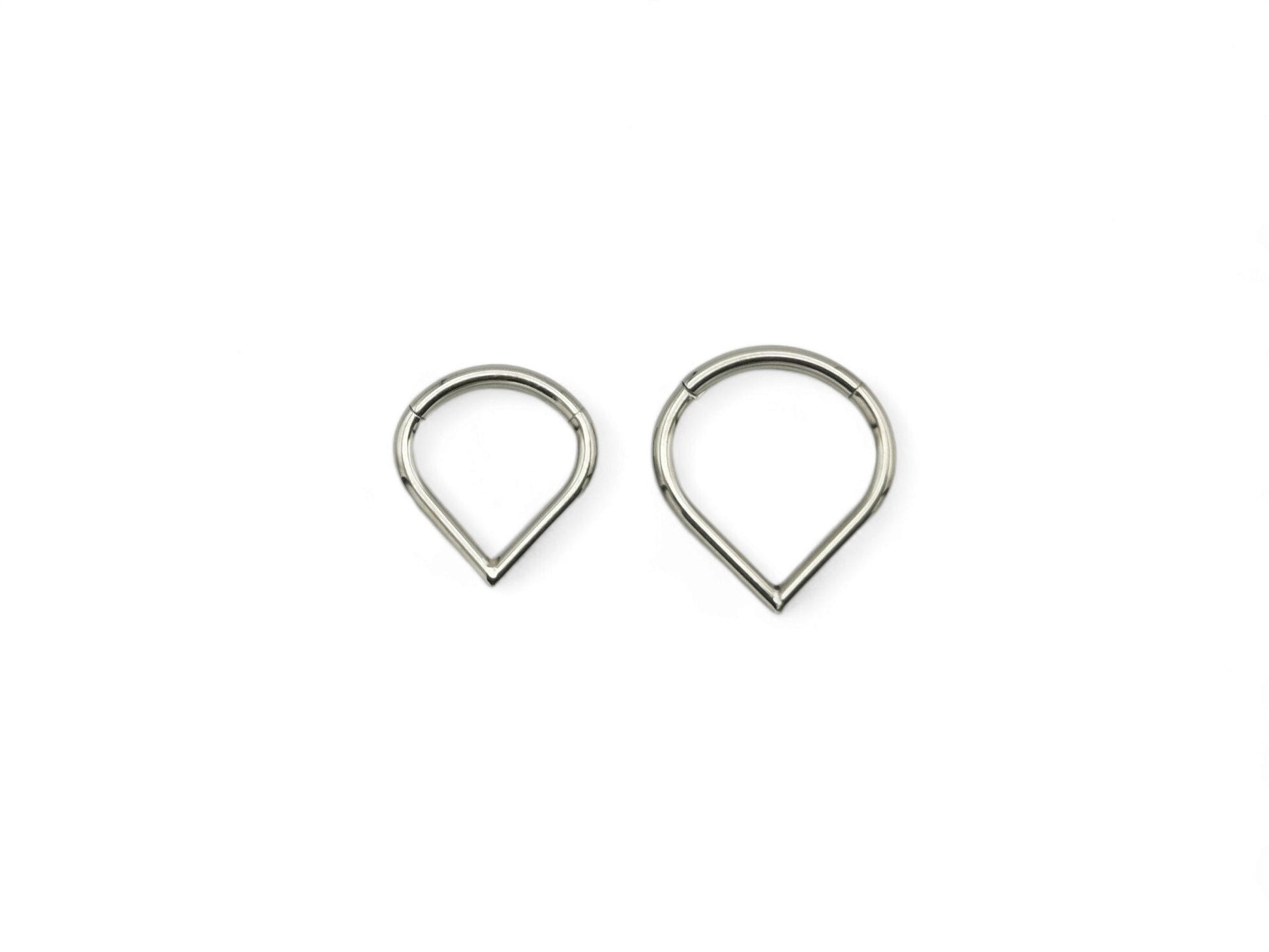 Two titanium wishbone clickers for piercings, with a shiny metallic finish, placed against a white background.