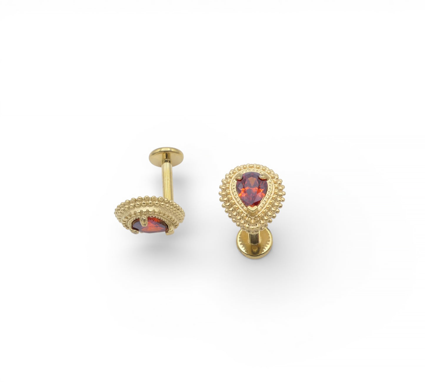 Gold earrings with red gemstones on a white background